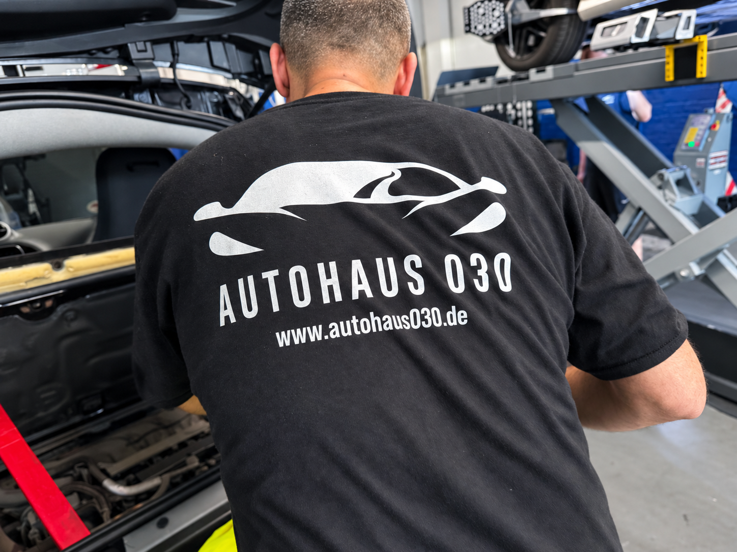 AUTOHAUS-030-Mitarbeiter bei der Arbeit an einem Fahrzeug.